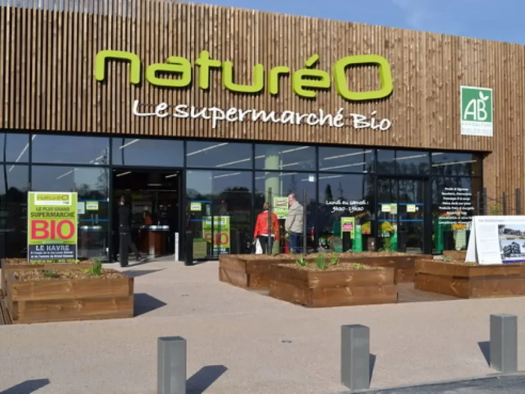Façade du magasin Naturéo Le Havre, le plus grand supermarché bio, avec un habillage en bois et le logo AB.