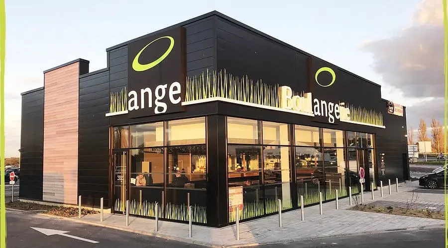 Intérieur Boulangerie Ange : vue sur le grand comptoir, les vitrines de sandwichs et pâtisseries, et les rayonnages de pains.