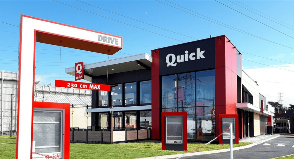 Façade extérieure d'un restaurant Quick au design contemporain rouge et noir.